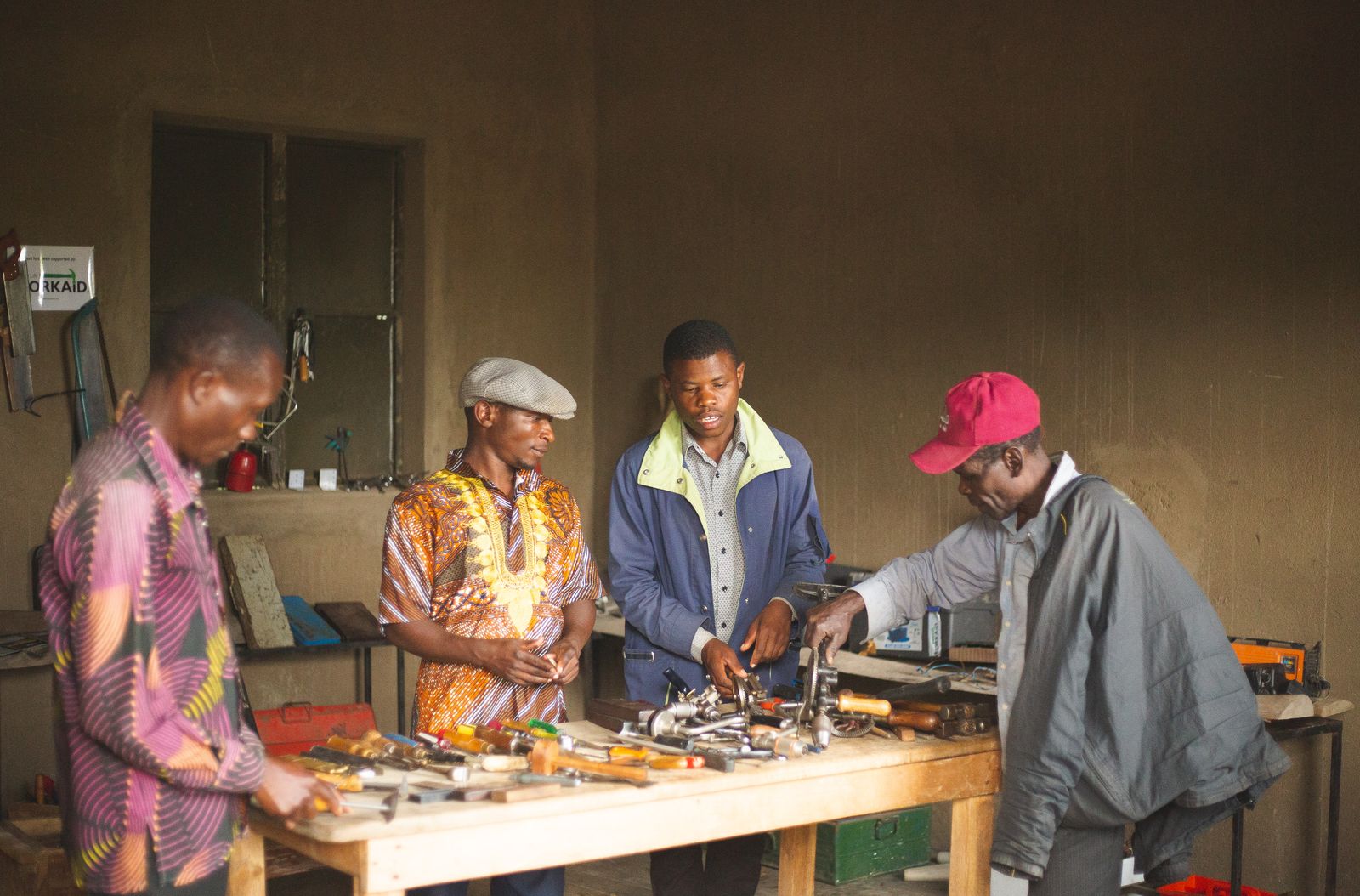 A group of young people collaborating around tools in a workshop