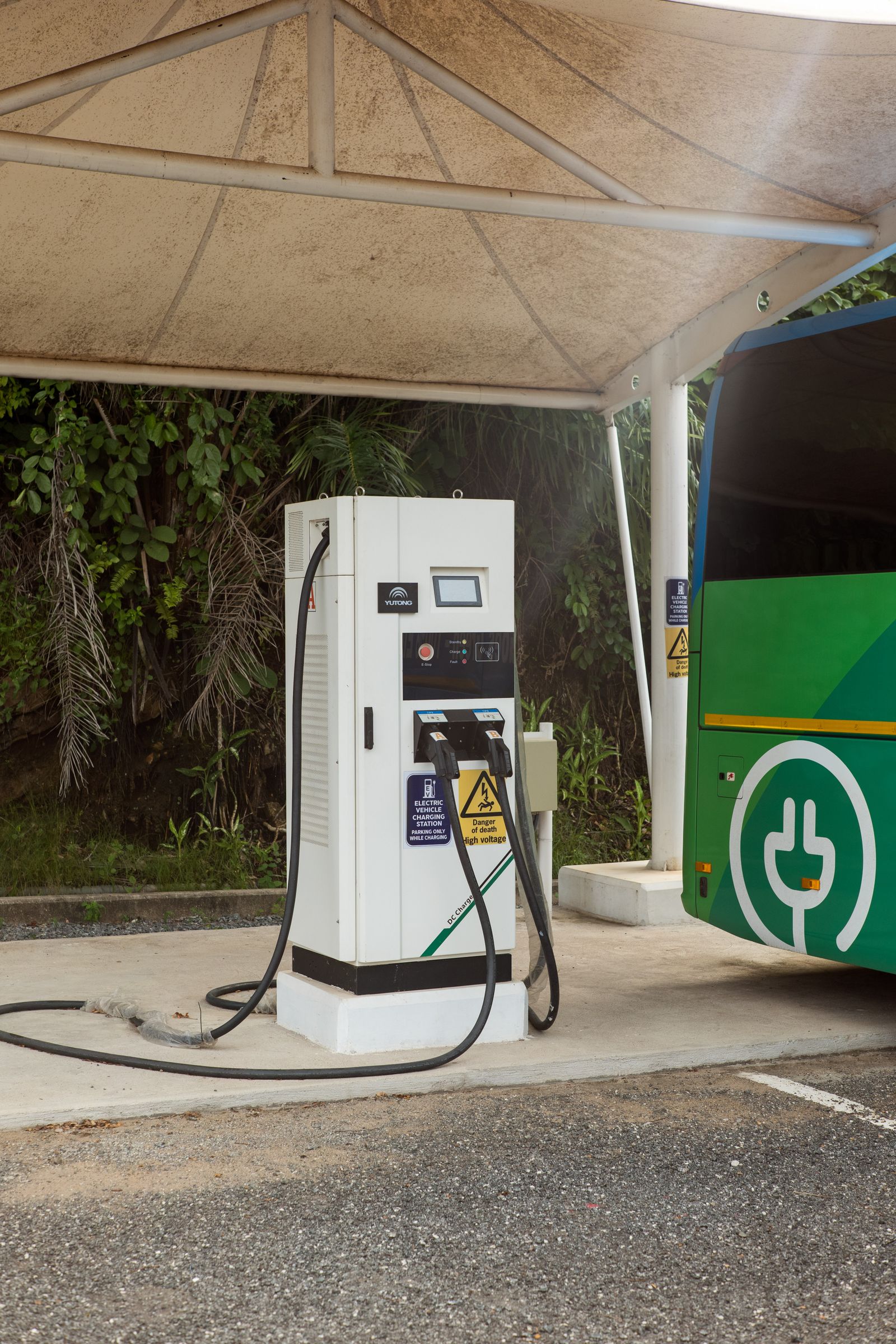 An electric bus charging station under a canopy